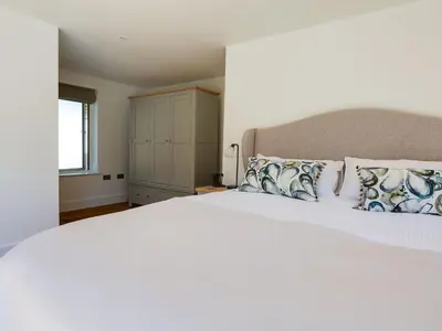 a bedroom with a large white bed with pillows at 1 Zeath in Polzeath
