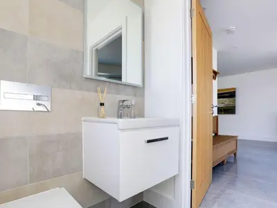 a white bathroom with a sink and a mirror at 1 Zeath in Polzeath