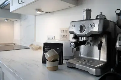 a coffee machine sitting on a counter in a kitchen at Palm Haven House - Luxury family-friendly Newquay surf house near Porth Beach perfect for walking, pets, exploring in Newquay