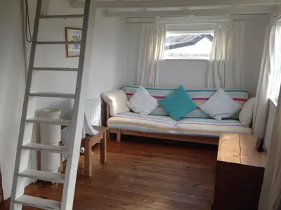 a living room with a couch and a ladder at Sunset Sea Views 1 min to beach On SW Coast Path Private Parking in Uny Lelant