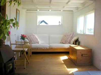a living room with a white couch and a window at Sunset Sea Views 1 min to beach On SW Coast Path Private Parking in Uny Lelant