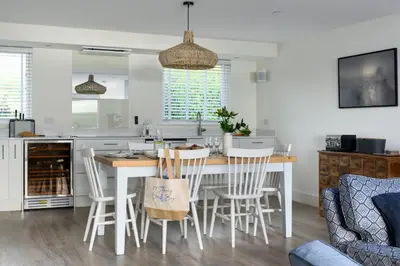 a kitchen and living room with a table and chairs at 17 Slipway in Padstow