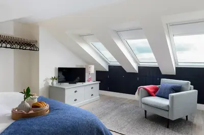 a bedroom with a bed and a chair and skylights at 17 Slipway in Padstow