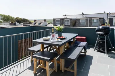 a table and chairs on a balcony with a camera at 17 Slipway in Padstow