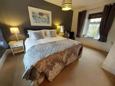 a bedroom with a large bed and a window at Boscastle House in Boscastle