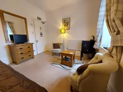 a living room with a couch and a tv at Boscastle House in Boscastle