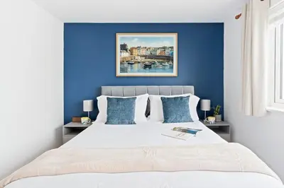 a bedroom with blue walls and a bed at Peaceful Harbour-View Cottage - Tresellick Gardens in Flushing