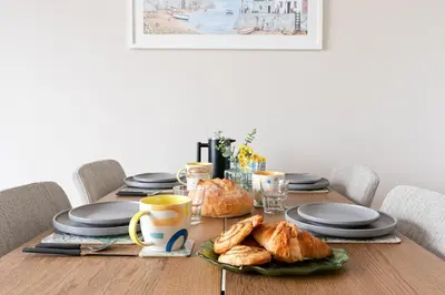 a table with croissants and cups and plates on it at Peaceful Harbour-View Cottage - Tresellick Gardens in Flushing