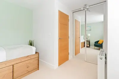 a bedroom with a bed and a sliding glass door at Peaceful Harbour-View Cottage - Tresellick Gardens in Flushing