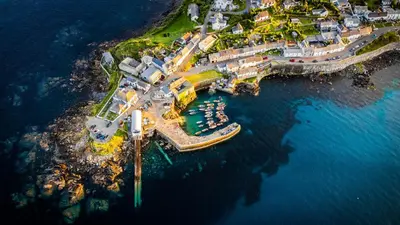 an aerial view of a harbor with boats in the water at Celtic Longhouse Tent at Coverack Camping in Coverack