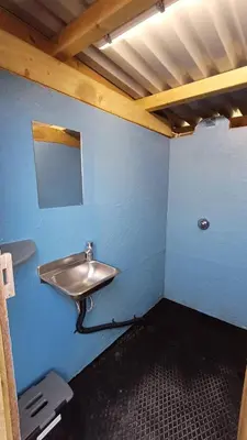 a bathroom with a sink in a blue wall at Celtic Longhouse Tent at Coverack Camping in Coverack