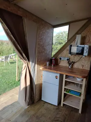 a kitchen in a tiny house with a window at Celtic Longhouse Tent at Coverack Camping in Coverack