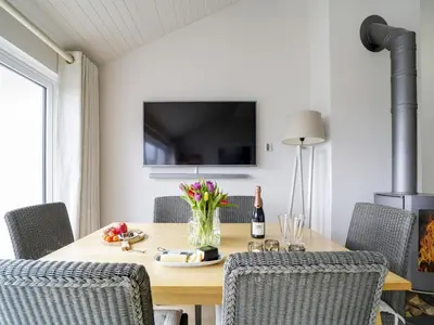 a dining room with a table with chairs and a television at 11 Slipway in Padstow