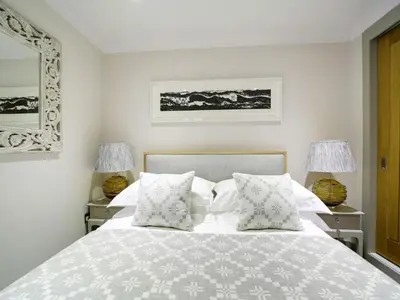 a bedroom with a white bed with pillows and two lamps at 11 Slipway in Padstow