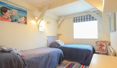 a room with two beds and a window in it at 23 Slipway in Padstow