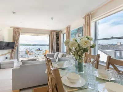 a living room with a table with a vase of flowers at 23 Slipway in Padstow