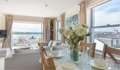 a living room with a table with a vase of flowers at 23 Slipway in Padstow
