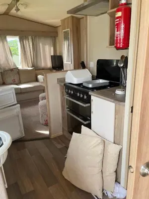 a small kitchen and living room in an rv at Caravan 163 sleeps up to 8 guests in Newquay