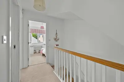 a hallway with a stairway leading to a bedroom at Finest Retreats - Cove House in St Austell