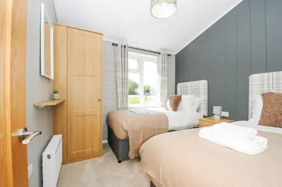 a bedroom with two beds and a window at 17 Meadow Retreat in Liskeard