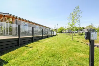 a building with a grass field next to a building at 17 Meadow Retreat in Liskeard