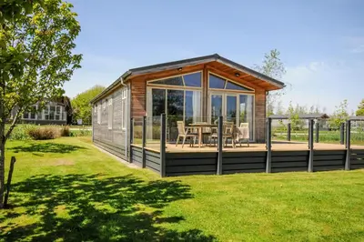 a small cabin with a deck in a yard at 17 Meadow Retreat in Liskeard