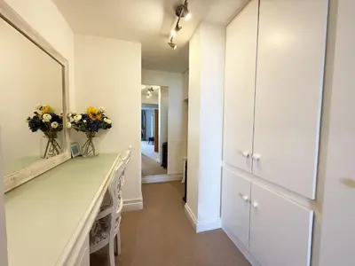 a dressing room with a mirror and flowers on a counter at Penthouse at Bredon in Newquay