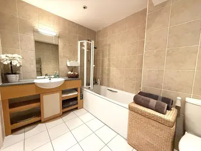 a bathroom with a sink and a tub and a toilet at Penthouse at Bredon in Newquay
