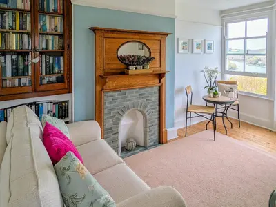 a living room with a couch and a fireplace at Denzell in Looe