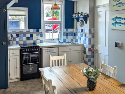 a kitchen with a table and a sink and a stove at Denzell in Looe
