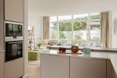 a kitchen and living room with a large window at 4 The Sands in Polzeath