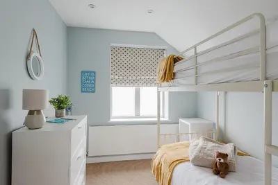 a bedroom with a white bunk bed with a ladder at 4 The Sands in Polzeath