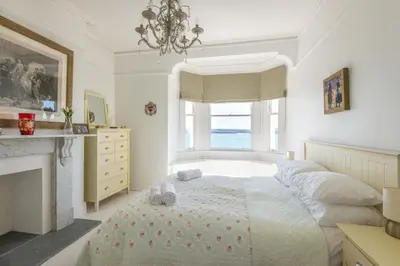 a bedroom with a bed with a fireplace and a window at 5 The Terrace in Padstow