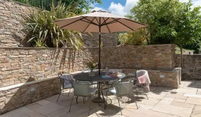 a table and chairs with an umbrella on a patio at 5 The Terrace in Padstow