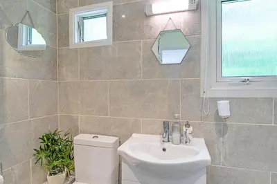 a bathroom with a toilet and a sink and a window at Finest Retreats - Lanteglos Villa in Camelford