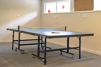a ping pong table in a room with a window at Finest Retreats - Lanteglos Villa in Camelford