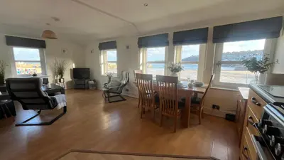 a kitchen and dining room with a table and chairs at Harts Loft - On Beach - Panoramic Sea Views - By Harbour in St Ives