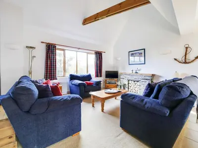 a living room with two blue couches and a fireplace at Casa Piedra in Polzeath