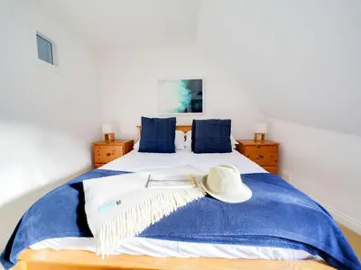 a bedroom with a bed with a hat on it at Casa Piedra in Polzeath