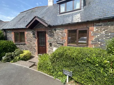 a brick house with a sign in front of it at Casa Piedra in Polzeath
