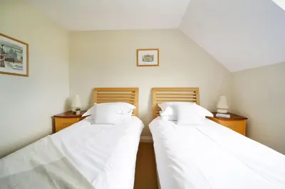 two beds sitting next to each other in a room at Chy Petroc in Polzeath