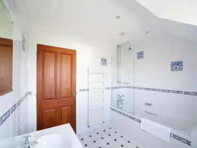 a bathroom with a tub and a sink and a shower at Chy Petroc in Polzeath