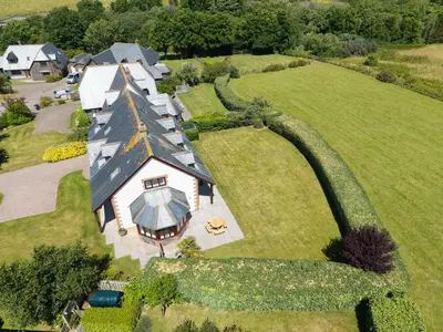 an aerial view of a large house on a green field at Chy Petroc in Polzeath
