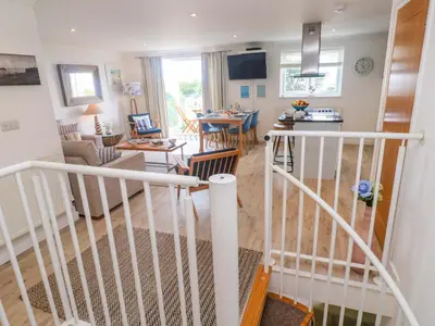 a view of a living room and kitchen with a staircase at Sea Breeze in Carbis Bay