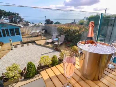 a bottle of champagne in a bucket on a deck at Sea Breeze in Carbis Bay