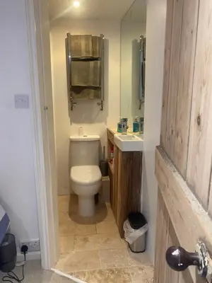 a bathroom with a toilet and a sink and a mirror at Hideaway Cottage in Camelford