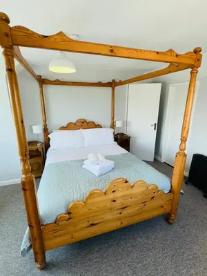 a bedroom with a wooden bed with a wooden frame at Moogara in Gorran Haven