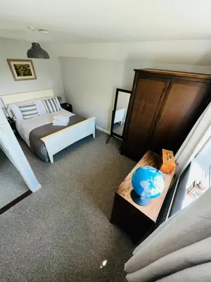 a bedroom with a bed and a table with a bowl on it at Moogara in Gorran Haven
