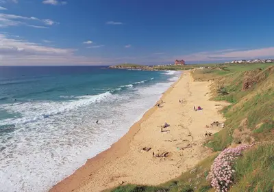 a beach with people on the sand and the ocean at Retallack hot tub lodge - 4 ensuites - luxury stay in Saint Columb Major