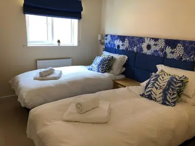 two beds with towels on them in a room at Retallack hot tub lodge - 4 ensuites - luxury stay in Saint Columb Major